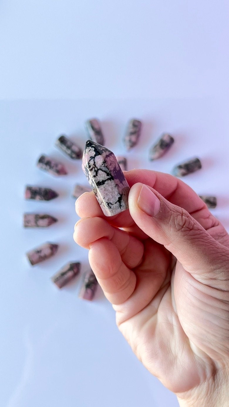 Colorful Rhodonite mini points 1 1/2 inch tall towers with a great pink color and black manganese throughout, Small and subtle crystals.