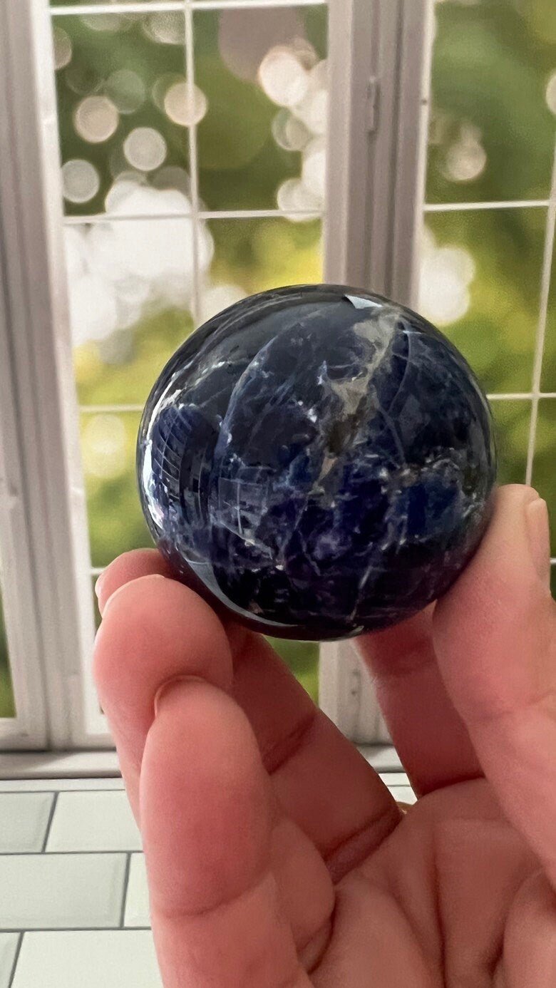 Stunning 2 inch Sodalite Sphere with deep royal blue color with a white calcite pattern, wooden stand included.