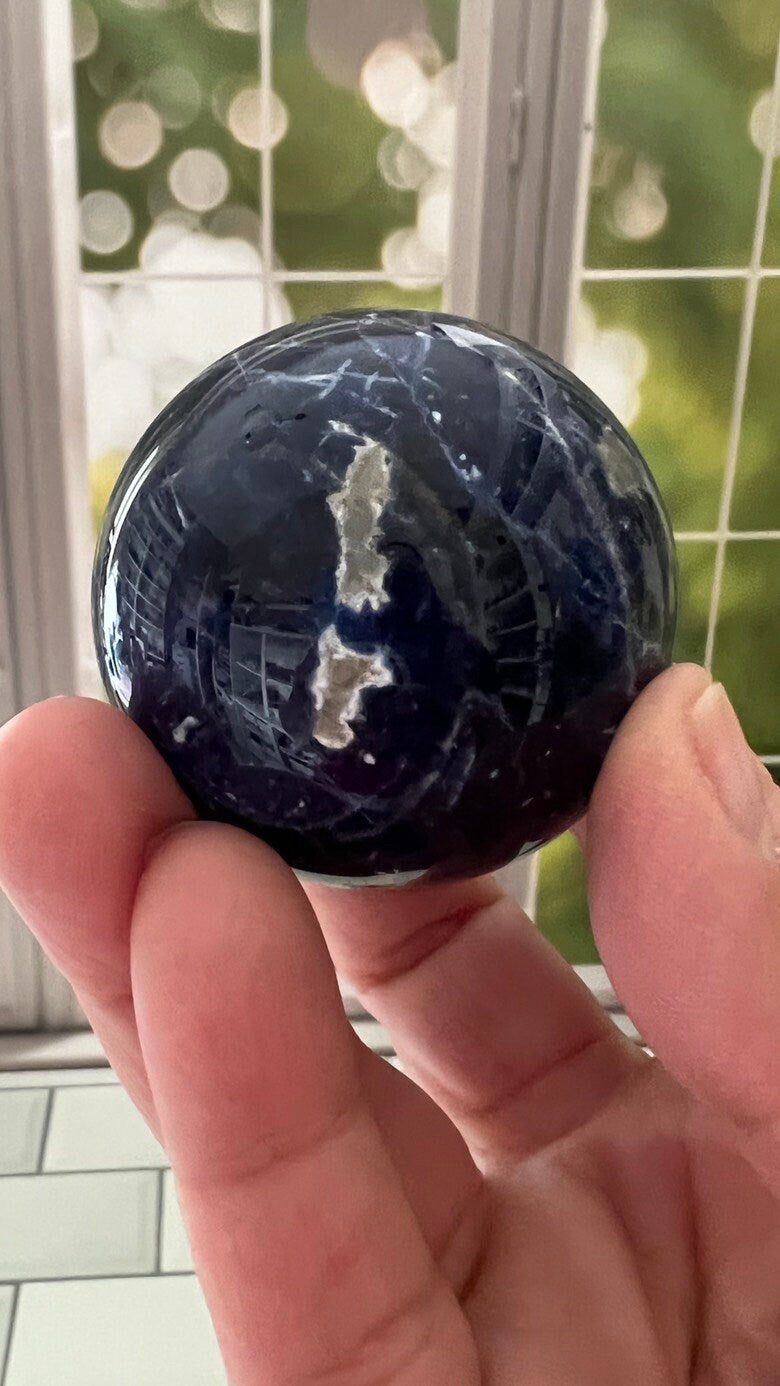 Stunning 2 inch Sodalite Sphere with deep royal blue color with a white calcite pattern, wooden stand included.
