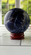 Load image into Gallery viewer, Stunning 2 inch Sodalite Sphere with deep royal blue color with a white calcite pattern, wooden stand included.
