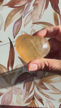 Load and play video in Gallery viewer, Beautiful Honey Calcite Heart Carving with rainbow inclusions 2 1/4 inches wide 2.8 ounces (HC-Heart2)
