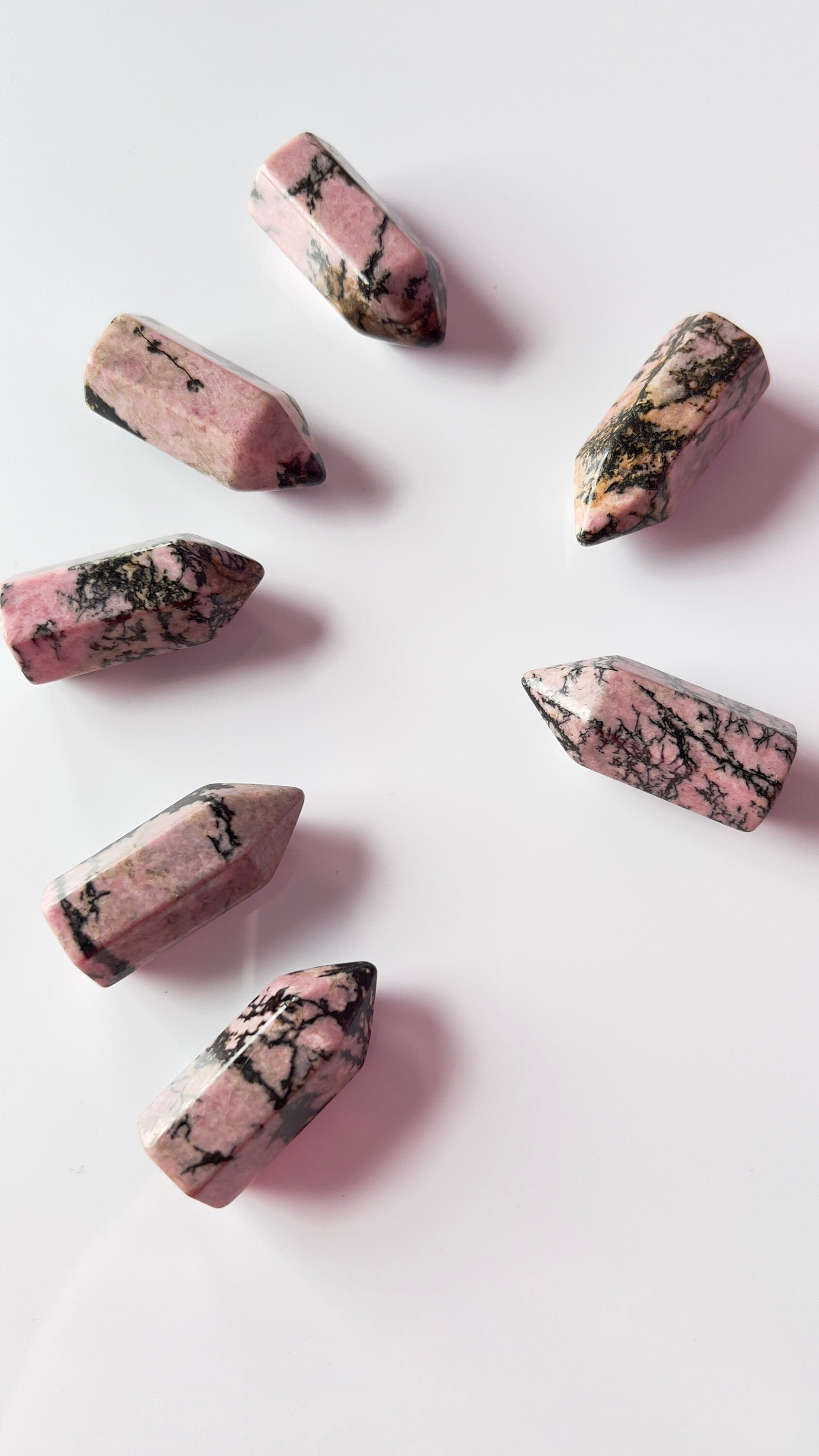 Colorful Rhodonite mini points 1 1/2 inch tall towers with a great pink color and black manganese throughout, Small and subtle crystals.