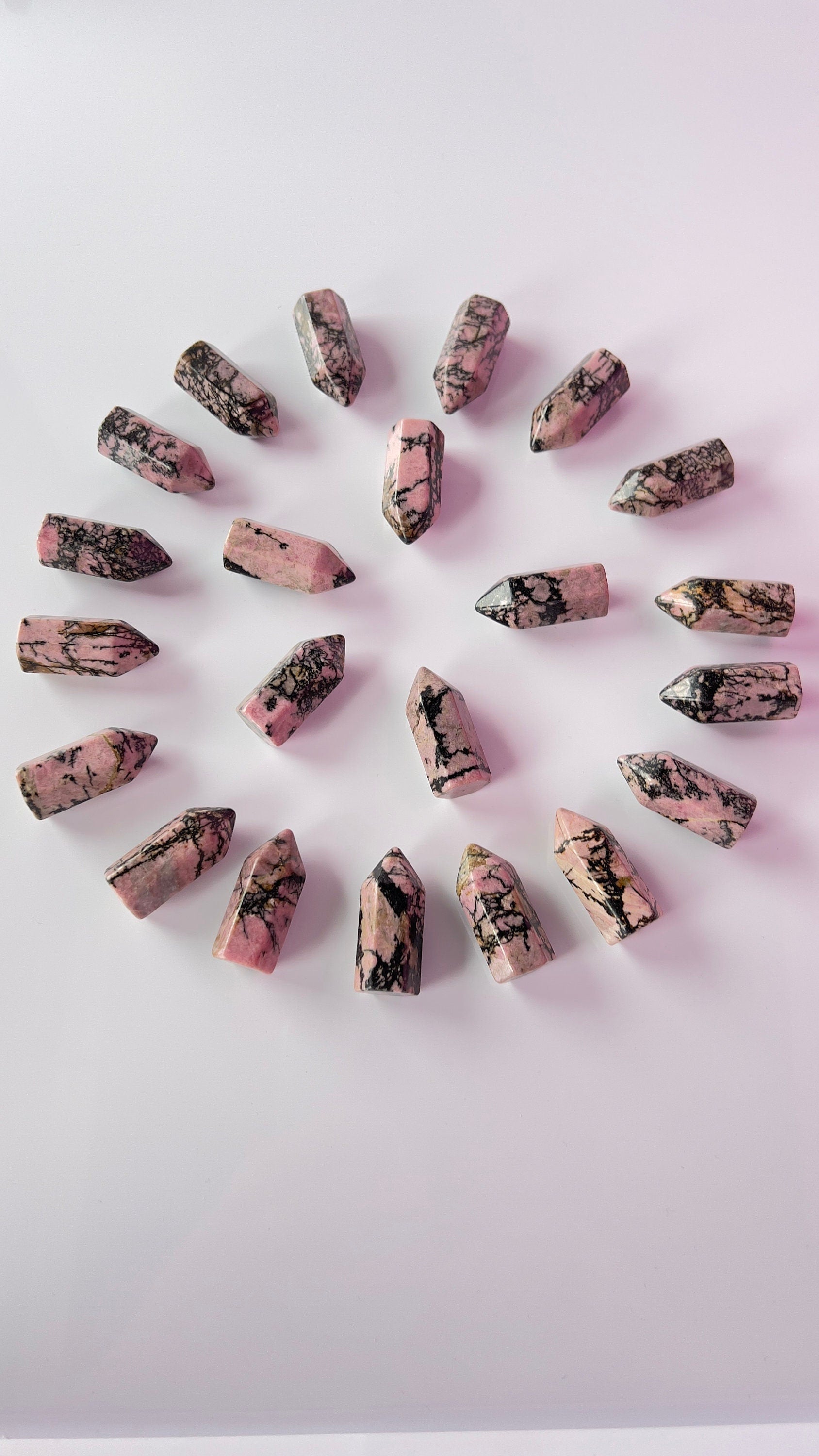 Colorful Rhodonite mini points 1 1/2 inch tall towers with a great pink color and black manganese throughout, Small and subtle crystals.